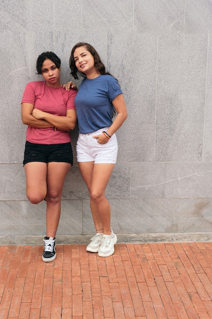 Lesbian couple standing on a city street while enjoying a day together.