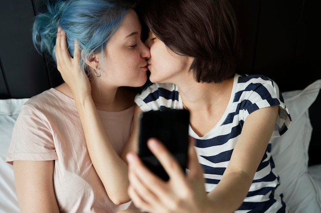 사진 레즈비언 커플이 키스하는 동안 셀피를 찍고 있다