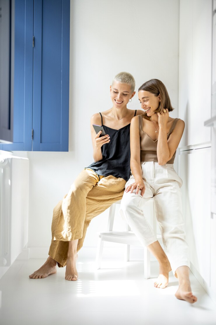 Lesbian couple with cell phone at home