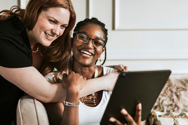 Lesbisch koppel dat een selfie maakt met een digitale tablet