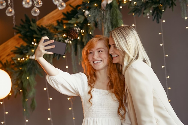 Lesbisch koppel neemt een selfie op hun telefoon, meisjes glimlachen en hebben samen plezier.