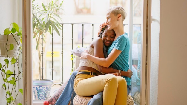 Lesbische geliefden omhelzen elkaar op het balkon.