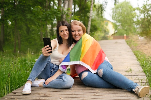 Lesbische vrienden worden samen gefotografeerd met een LGBT-vlag op de schouder