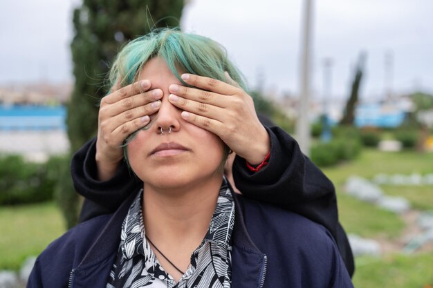 Lesbische vrouw die de ogen van haar partner buitenshuis bedekt