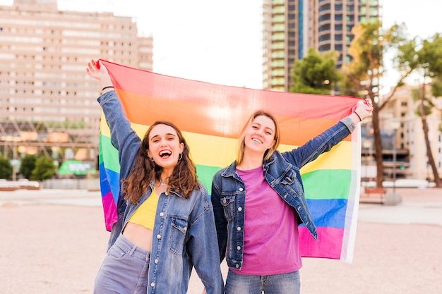 Lesbische vrouw jong multi-etnisch koppel met een regenboogvlag diversiteit concept