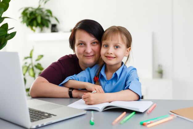 Lessen op afstand. Het kind lacht vrolijk en krijgt kennis op afstand. Klein meisje studeert online leren vanuit huis. Onlineschool.