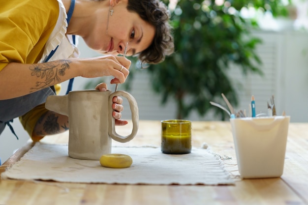 Lesson of pottery in workshop artist woman learn to work with ceramic and clay for creating potter