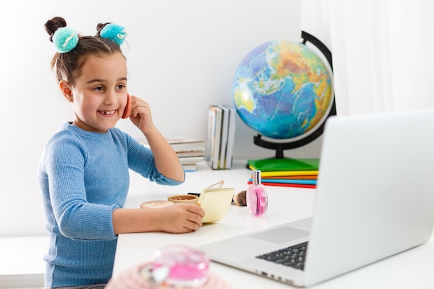 lessons of makeup on the computer girl looks and wants to repeat the make-up for the face