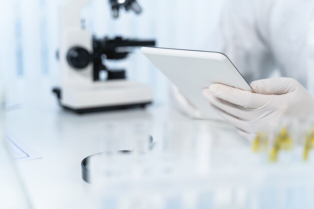 Photo let me check. modern scientist working in laboratory in sterile uniform while doing chemical experiments
