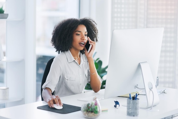 Let me just open the document on my pc Shot of a young businesswoman talking on a cellphone in an office