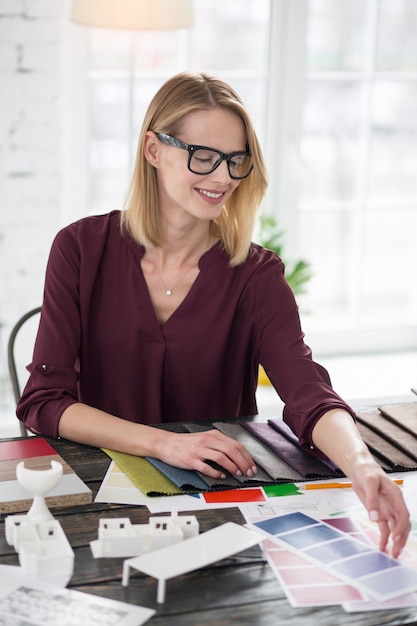 Fammi pensare. designer femminile energico che allunga il campione della mano durante il prelievo del colore