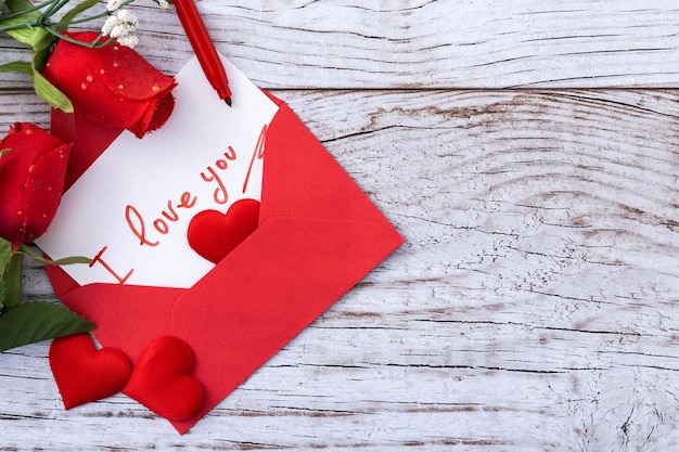 Let op dat zegt "Ik hou van jou" in een envelop met hartjes en rozen op houten tafel