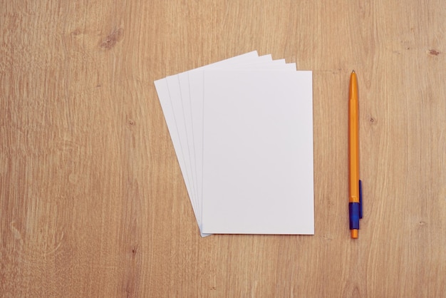 Let op papieren of kaarten en een gele pen op een houten tafel.