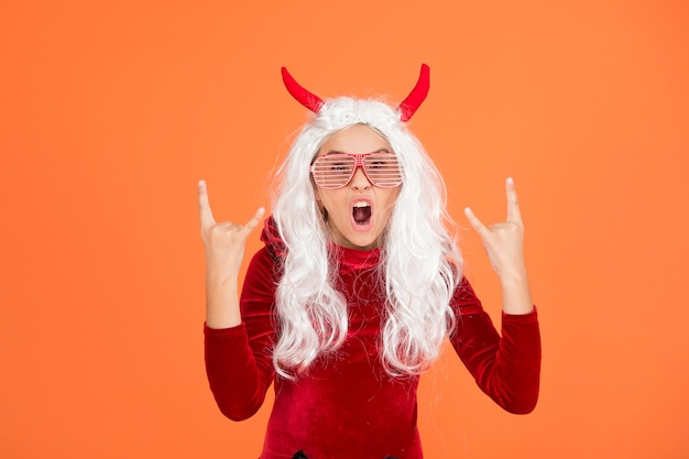 Let the party begin. carnival costume party. trick or treat. celebrate the holidays. happy halloween devil girl. teenage child in imp horns. cheerful kid with white hair in fanny glasses.