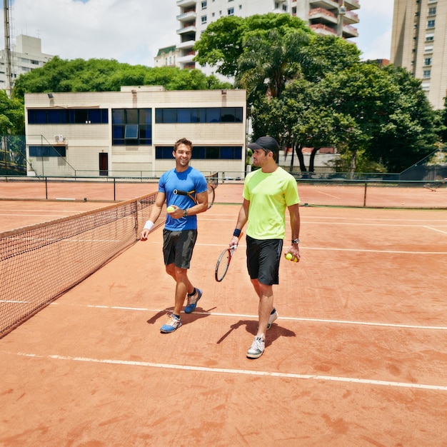 코트에서 이야기하는 두 명의 테니스 선수의 경기가 끝난 후 따라잡을 수 있습니다.
