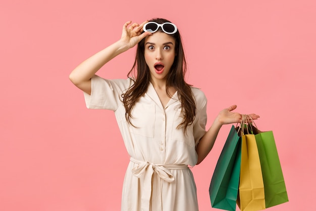 쇼핑하러 가자. 즐겁고 흥분된 여성 쇼핑 중독자가 쇼핑 몰을 통해 탐색하는 재미, 쇼핑 가방을 들고, 찾고있는 것을 정확히 보는 이륙 안경, 분홍색 벽