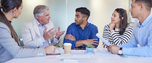 Lets learn from him. Shot of a group of businesspeople having a meeting at work.