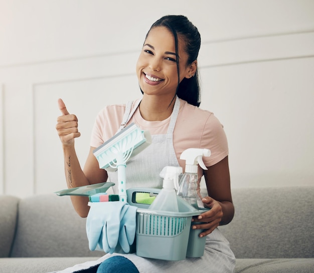 Lets make this place spotless. Shot of a woman holding a basket with cleaning supplies at home.