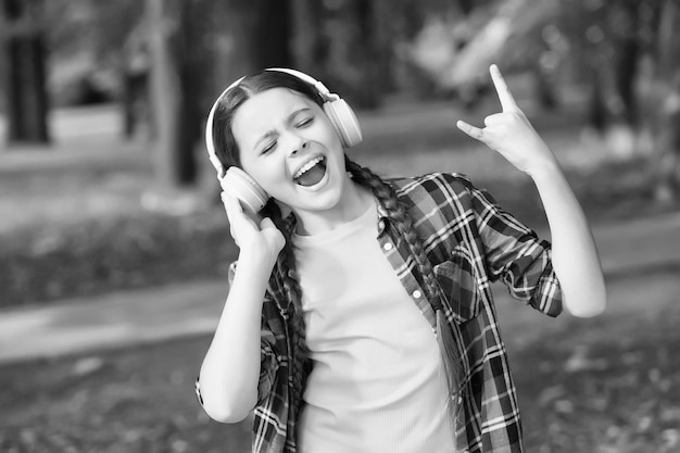 Lets rock happy kid show horns hand gesture singing along to\
music listen technology modern lifestyle fashion look childrens day\
summer vacation rock and roll soul