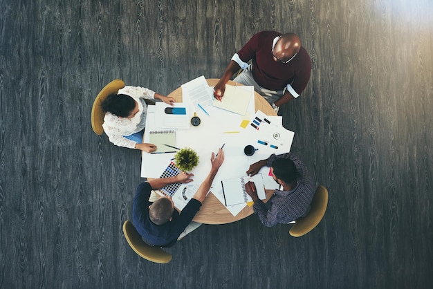 Lets talk profit High angle shot of a group of businesspeople having a meeting in a modern office