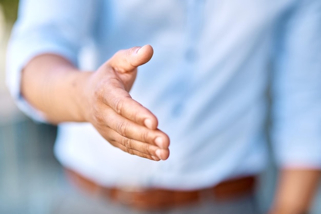 Lets do this shall we Cropped shot of an unrecognizable businessman standing with his hand extended for a handshake during the day