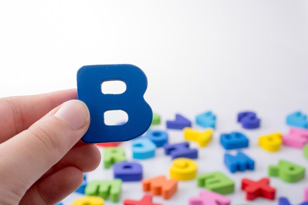 Letter B in de hand naast kleurrijke letterblokken