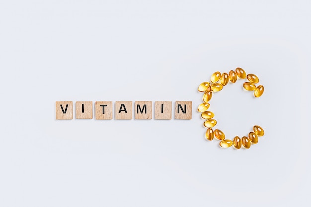 Letter C made from transparent pills near the inscription Vitamin
