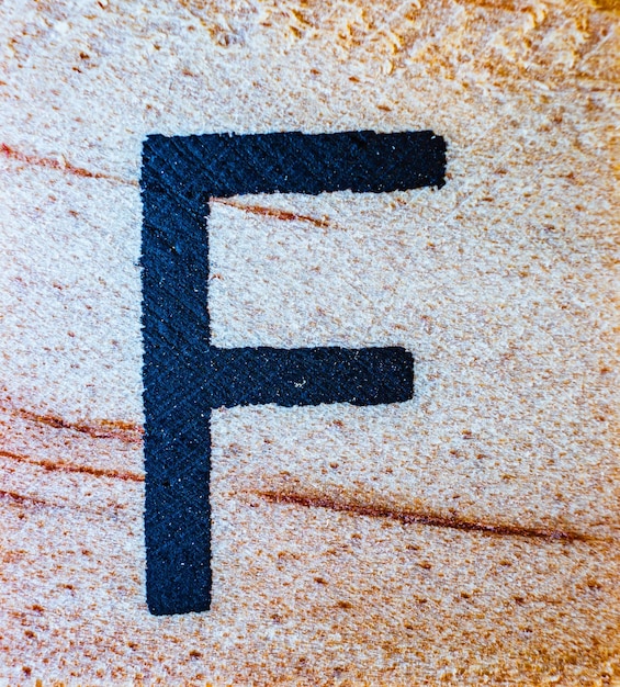 Photo letter f laser engraved on balsa wood macro close up texture detail