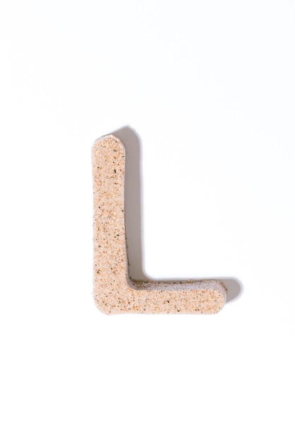 Letter L of the sand isolated in white summer concept alphabet