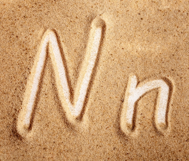 Буква N английского рукописного алфавита в песке
