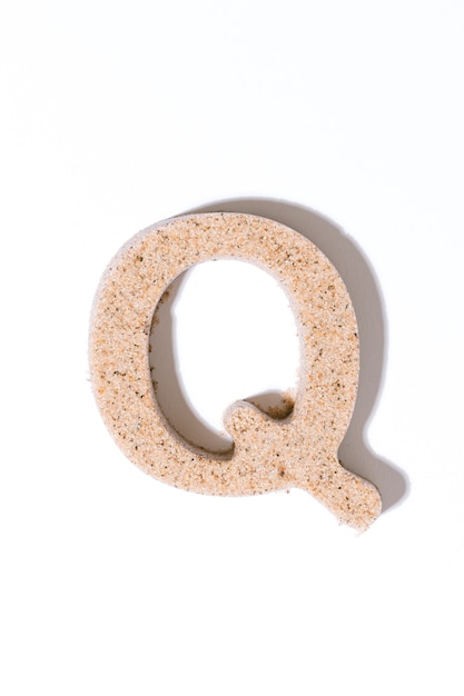 Letter Q of the sand isolated in white summer concept alphabet