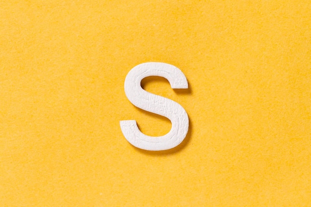 Letter S of the alphabet isolated on yellow background top view