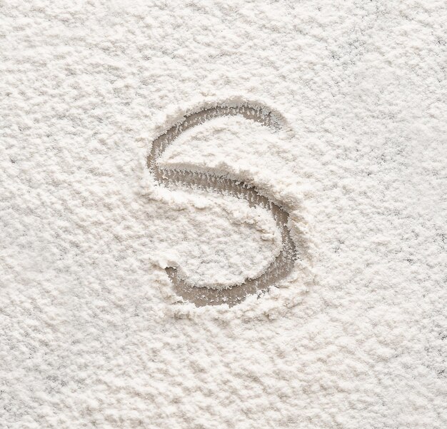 Letter S written on flour