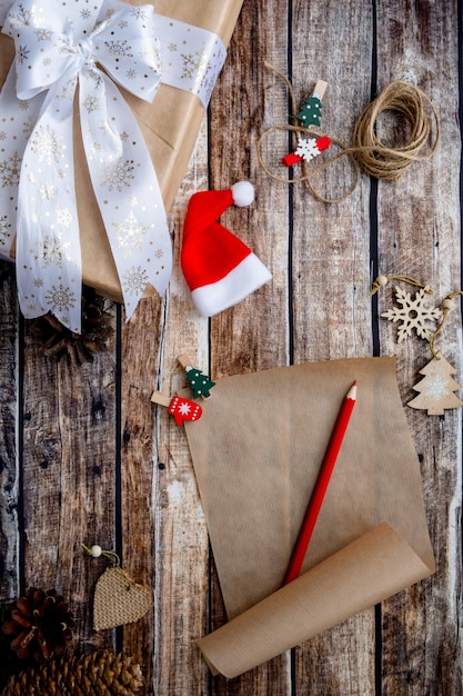 Letter to santa claus, christmas wishlist on wooden background among holiday
decoration