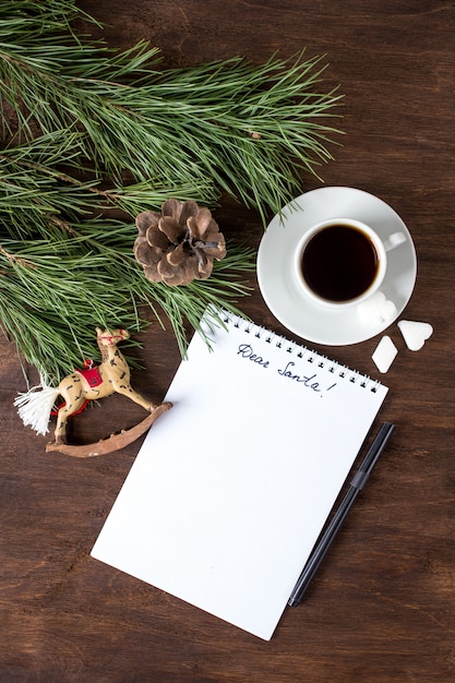 A letter to Santa on the table with tea and Christmas ornaments 