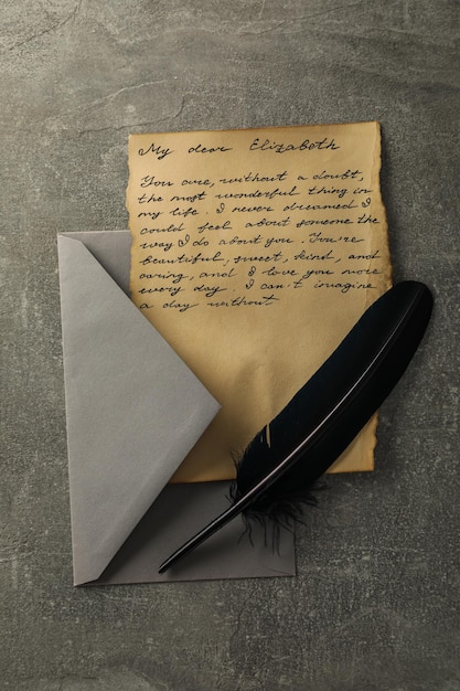 Letter with text gray envelope and feather on gray background top view