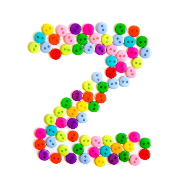 Photo letter z of the english alphabet from a group of colorful small buttons on white