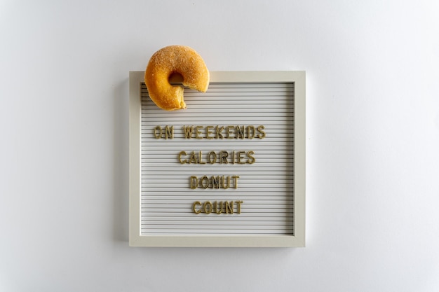 Letterboard With Words That Spell On Weekends Calories Donut Count in golden letters with a fresh do