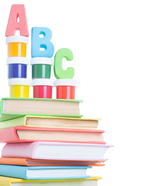 Foto lettere abc e pila di libri su sfondo bianco