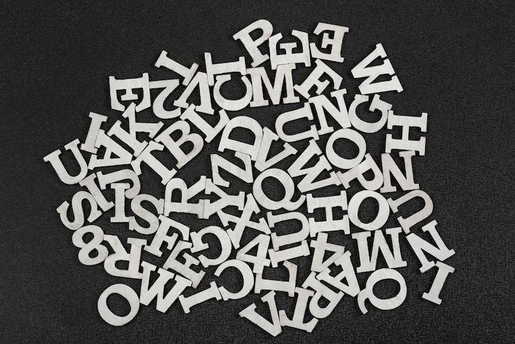 Photo 黒い空間に混沌とした順序で配置された英語のアルファベットの文字。トップwiev