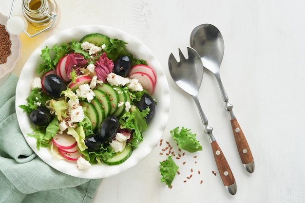 Салат из листьев салата, салат из огурцов, редьки с творогом и семенами льна, салат из оливкового масла, здоровое диетическое питание, диетическое меню и сбалансированное питание, вид сверху