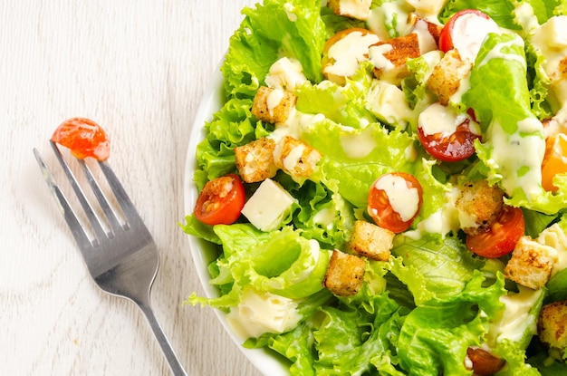 Lettuce tomato and cheese salad croutons dressing White background