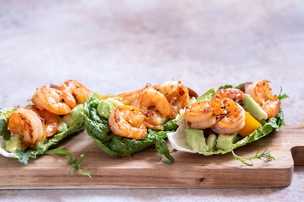 Foto tacos di gamberi avvolti in lattuga con pomodoro fresco, avocado e lime