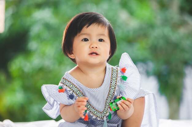 Leuk Aziatisch babymeisje die met haar stuk speelgoed met geluk spelen