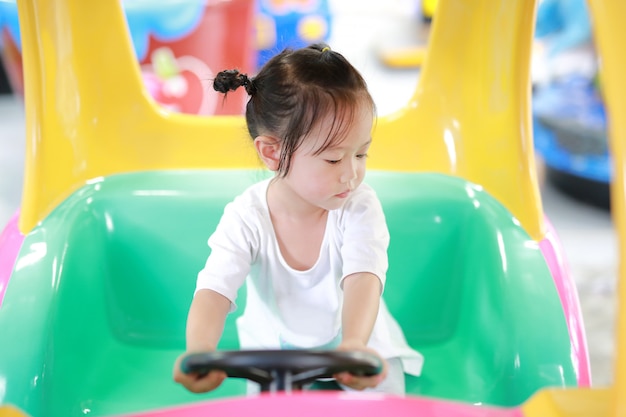 Leuk aziatisch babyspel in stuk speelgoed auto, speelgrond