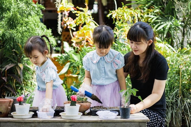 Leuk Aziatisch kindmeisje die moeder helpen die de installaties in de tuin planten of cutivate.