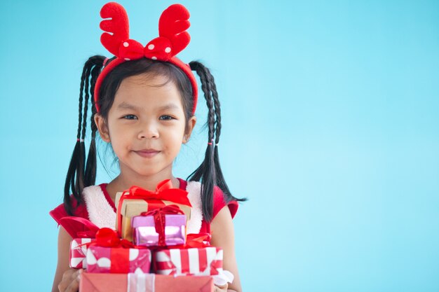 Leuk Aziatisch kindmeisje die mooie gift houden op Kerstmisviering in hand