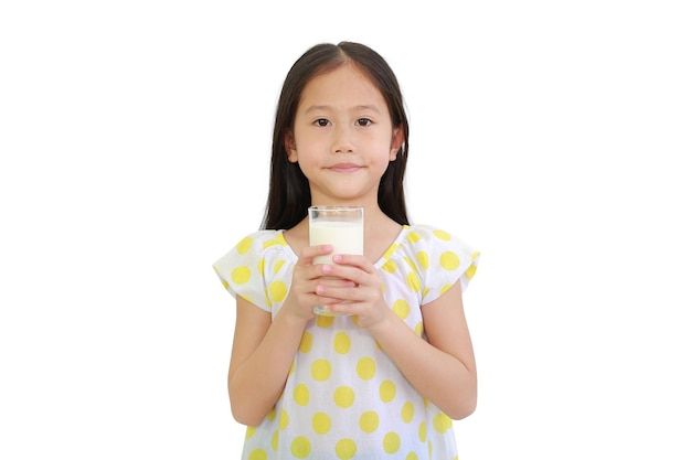 Leuk aziatisch klein kindmeisje met glas melk dat op witte achtergrond wordt geïsoleerd