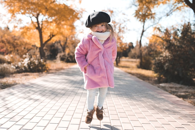 Leuk babymeisje dat pluizige roze jas en hoed draagt