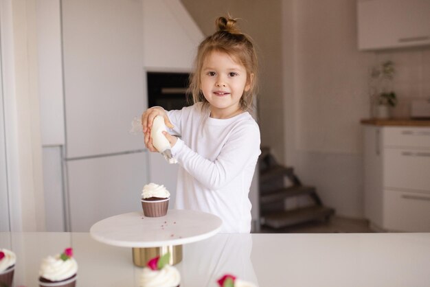 Leuk babymeisje die smakelijke cupcake maken